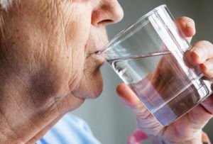 Senior woman drinking water - battling dehydration among seniors