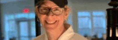 Woman in white chef's coat smiling
